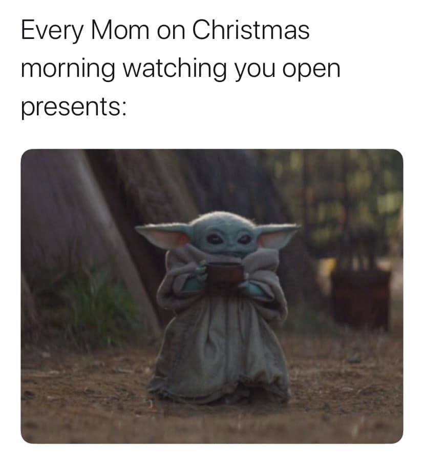 This meme is a humorous image featuring a character from the Star Wars franchise, Baby Yoda, from the Disney+ series "The Mandalorian". The image shows Baby Yoda holding a cup of coffee and looking sleepy, with the caption "When your parents wake you up on Christmas morning" and the text "Every mom: 'It's Christmas! Time to wake up my child and ruin their holiday'". The meme pokes fun at the common experience of being woken up on Christmas morning by a parent, and Baby Yoda's sleepy expression adds to the humor.